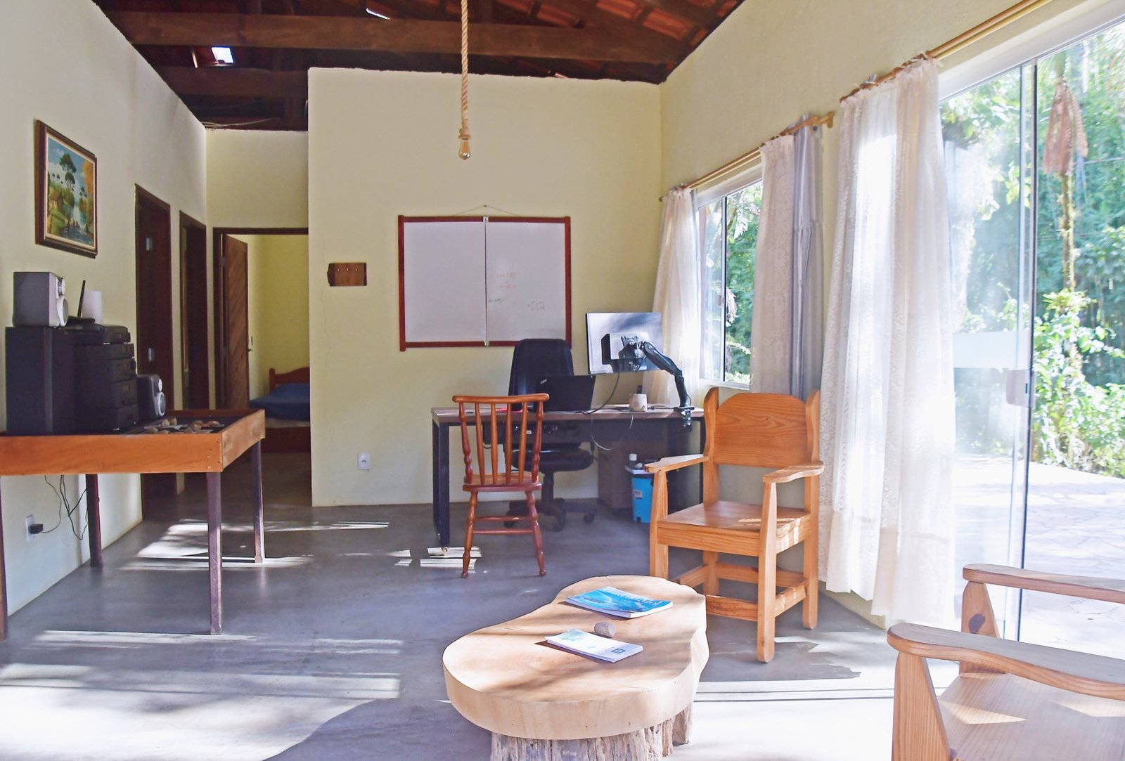 Sala iluminada com mesa de trabalho e portas de vidro