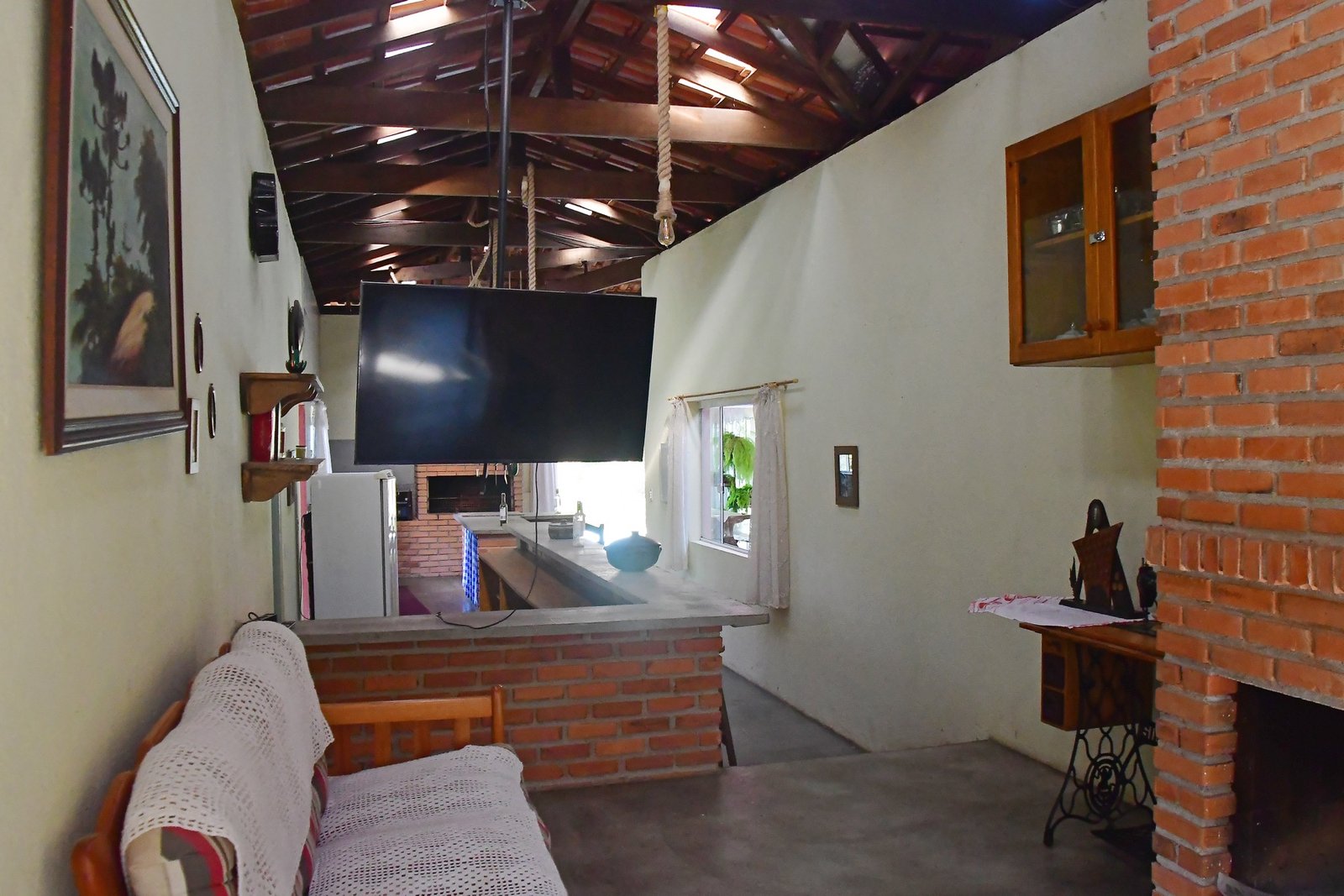 Ambiente interno com lareira e cozinha ao fundo