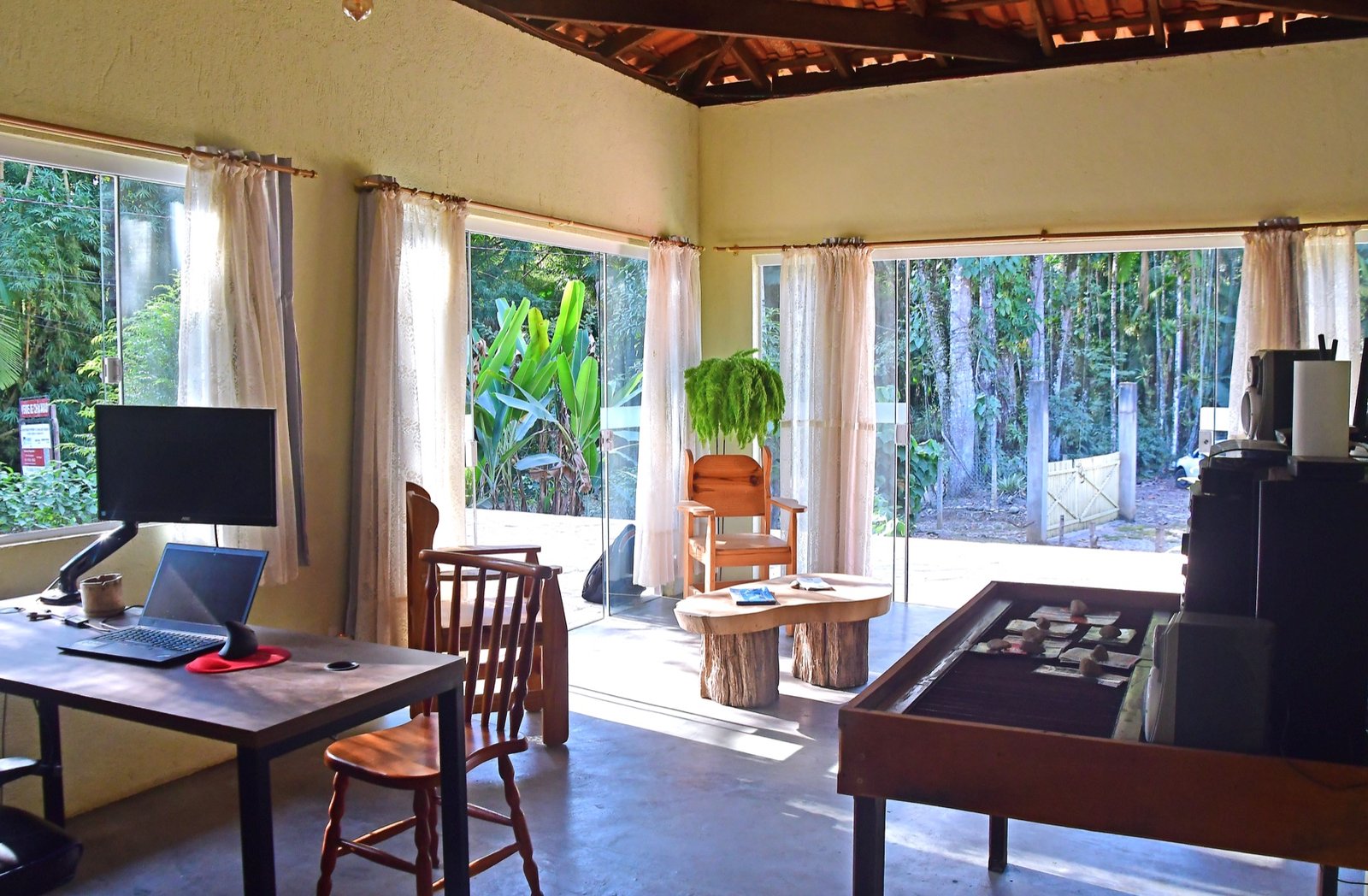 Sala com portas de vidro e vista para a vegetação
